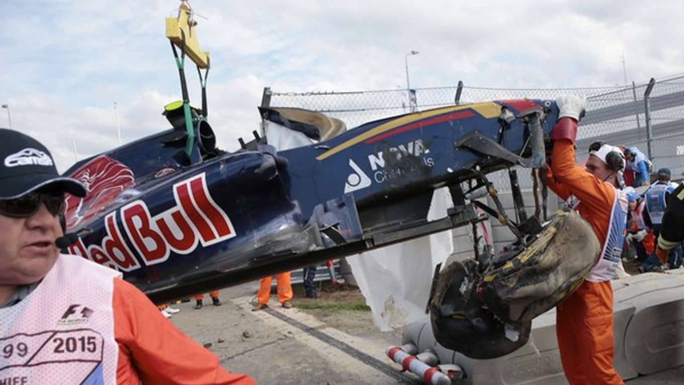 Traťoví maršali odstraňujú zničený monopost Carlosa Sainza.