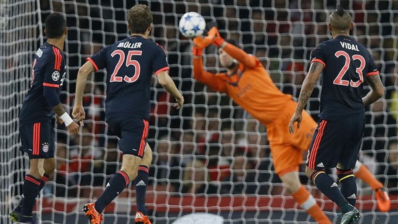 Brankár Arsenalu Petr Čech vyráža strelu hráča Bayernu Mníchov Artura Vidala (vpravo).