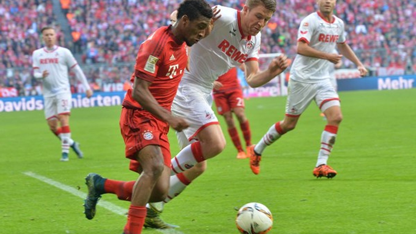 Hráč Bayernu Kingsley Coman (v červenom drese) sa snaží preniknúť s loptou cez futbalistu Kolína Dominiqueho Heinza.