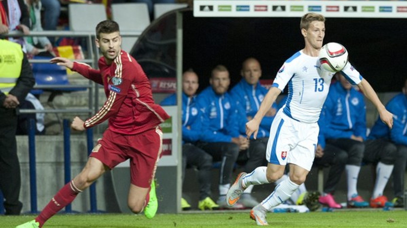 Patrik Hrošovský (vpravo) zasiahol aj do zápasu kvalifikácie o postup na majstrovstvá Európy 2016 v Španielsku. Na snímke získava loptu po súboji s Gerardom Piquém.