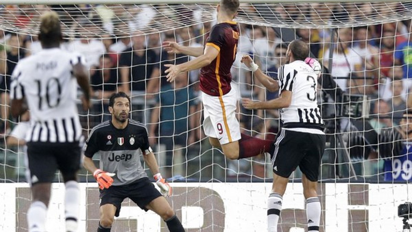 Edin Džeko (č. 9) práve hlavou strieľa rozhodujúci gól zápasu, v ktorom AS Rím porazilo majstrovský Juventus.