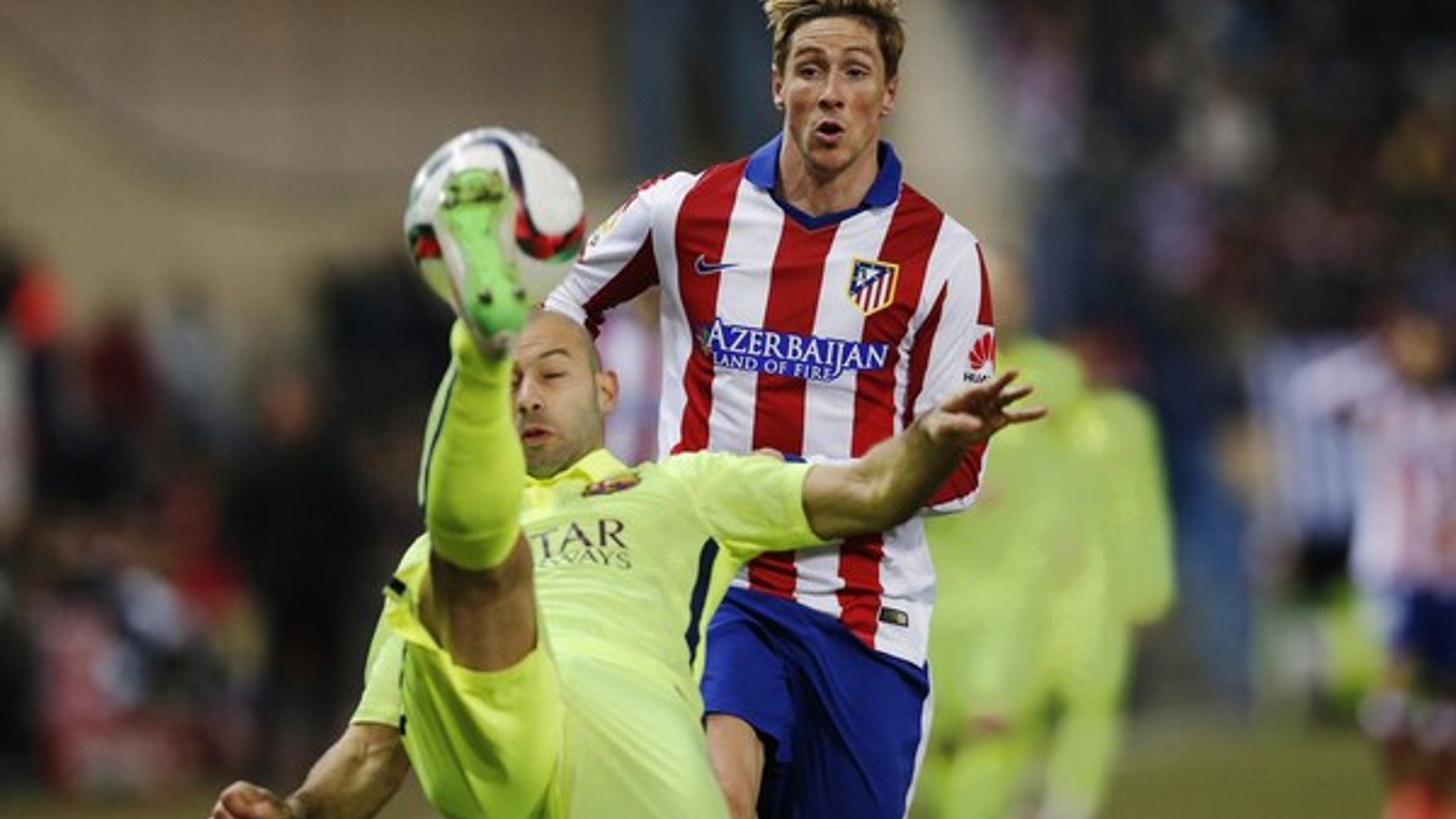 Javier Mascherano odkopáva loptu pred nabiehajúcim Fernandom Torresom.