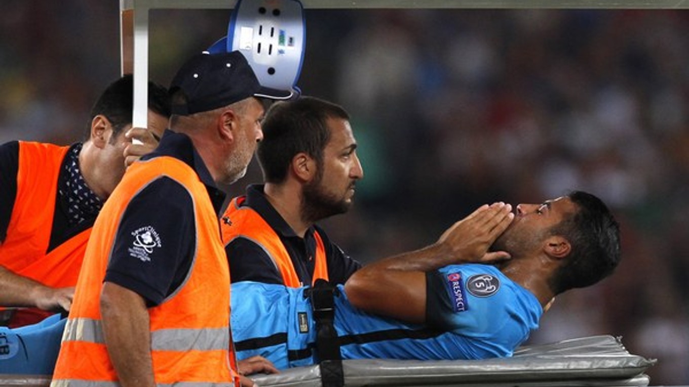 Zraneného futbalistu Barcelony Rafinhu odnášajú na nosidlách z ihriska v zápase Ligy majstrov v Ríme.
