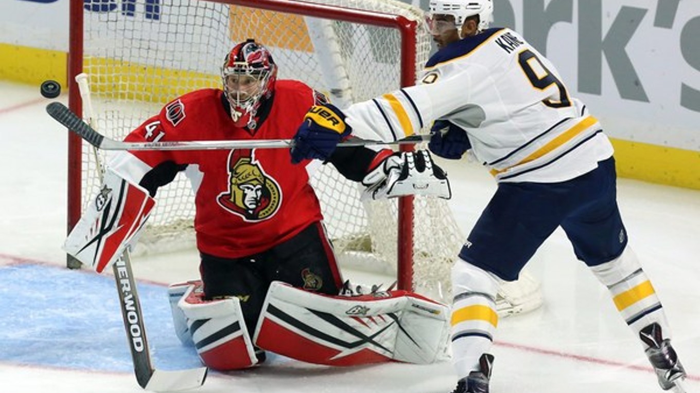 Hokejista Buffala Sabres Evander Kane sa pokúša zasiahnuť puk vo vzduchu pred brankárom Ottawy Senators Craigom Andersonom.