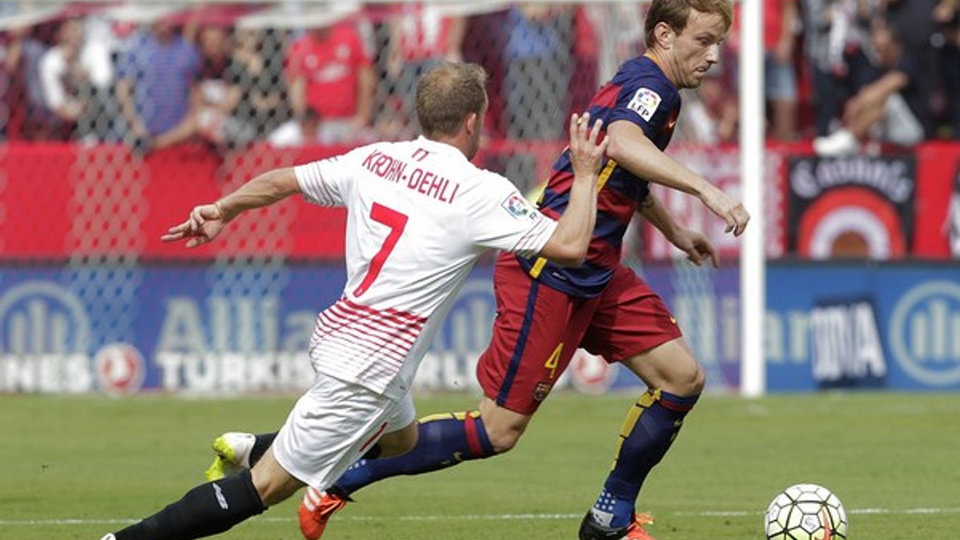 Hráč Barcelony Ivan Rakitič (vpravo) obchádza s loptou Michaela Krohna-Dehliho z FC Sevilla.