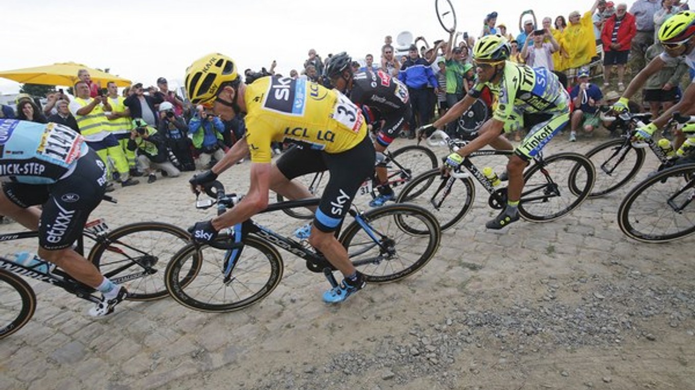 Alberto Contador prenasleduje na úseku s pavé v žltom tričku jazdiaceho Chrisa Frooma.