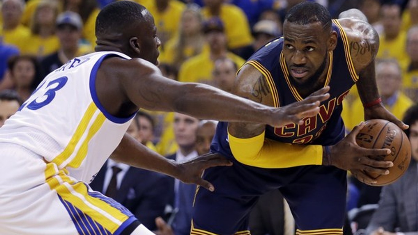 LeBron James (vpravo) sa v zápase finále NBA snaží uvoľniť cez brániaceho Draymonda Greena z Golden State.