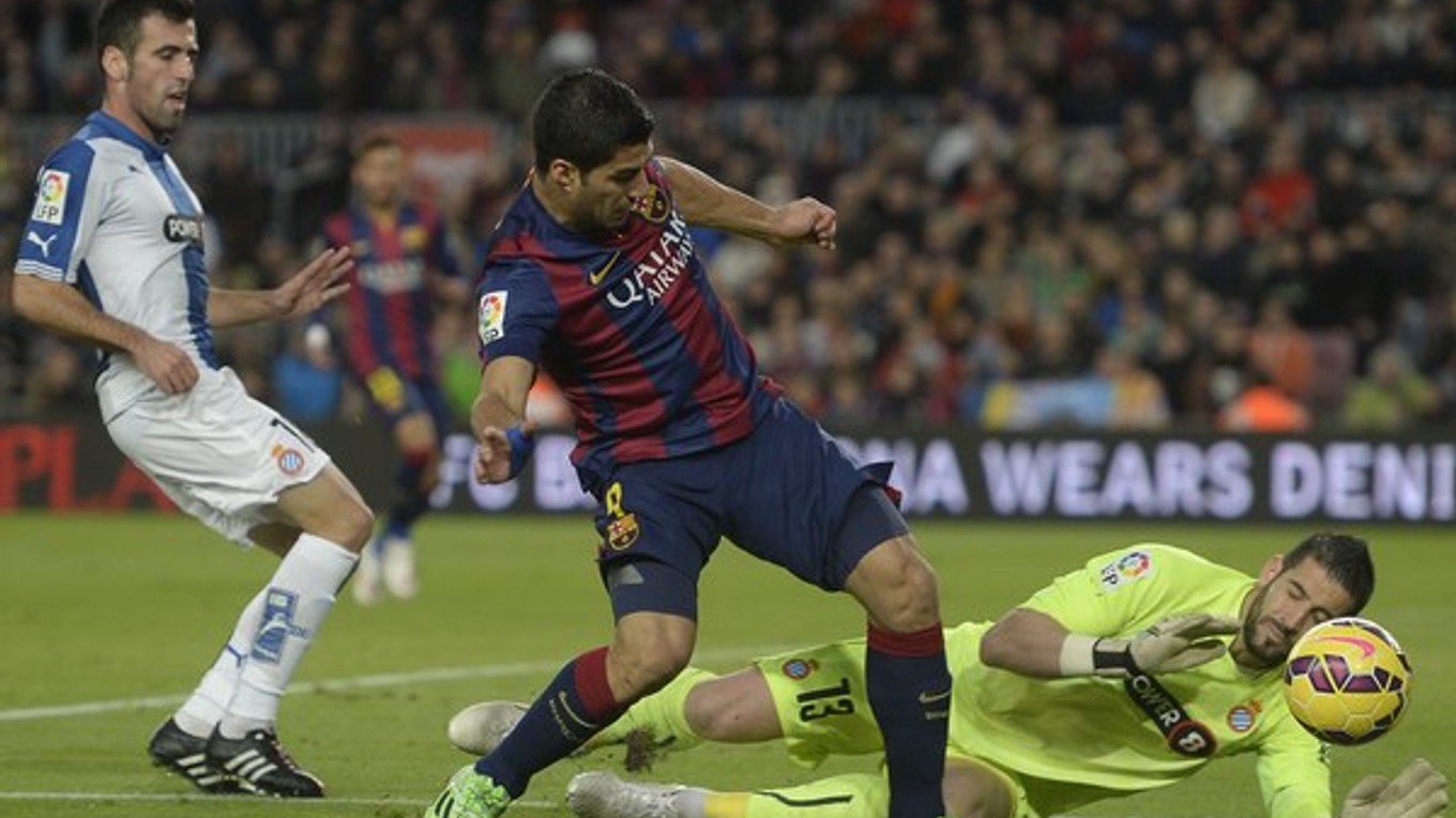 Kiko Casilla (vpravo) sa snaží chytiť loptu pred dobiehajúcim Luisom Suárezom z FC Barcelona.