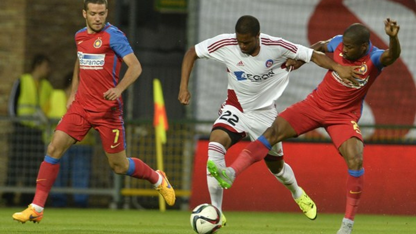 Futbalista Trenčína Ramón (v strede) sa pokúša s loptou predrať pomedzi dvoch hráčov tímu Steaua Bukurešť.