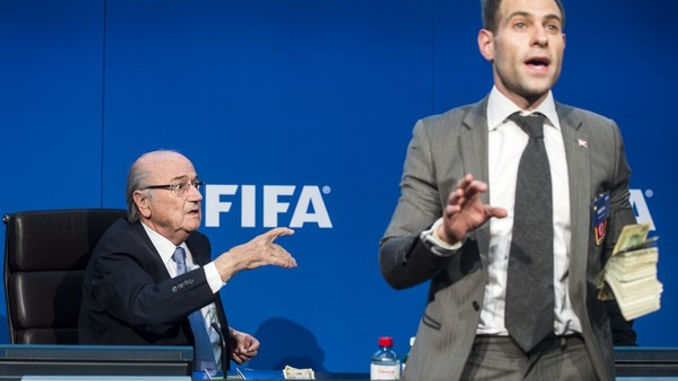 Britský komik Simon Brodkin začal hádzať na prezidenta FIFA Sepa Blattera falošné bankovky.