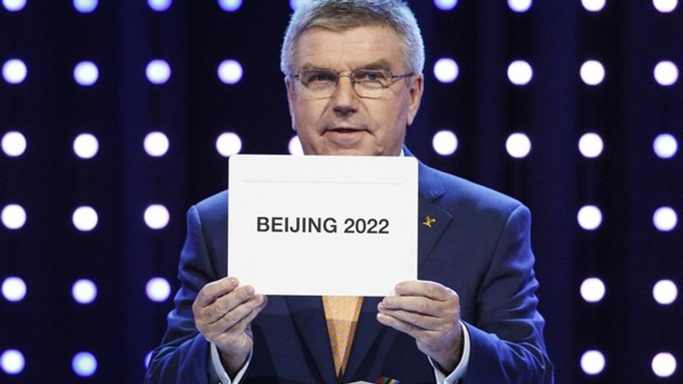 Prezident Medzinárodného olympijského výboru Thomas Bach vyťahuje z obálky meno organizátora zimných olympijských hier v roku 2022.