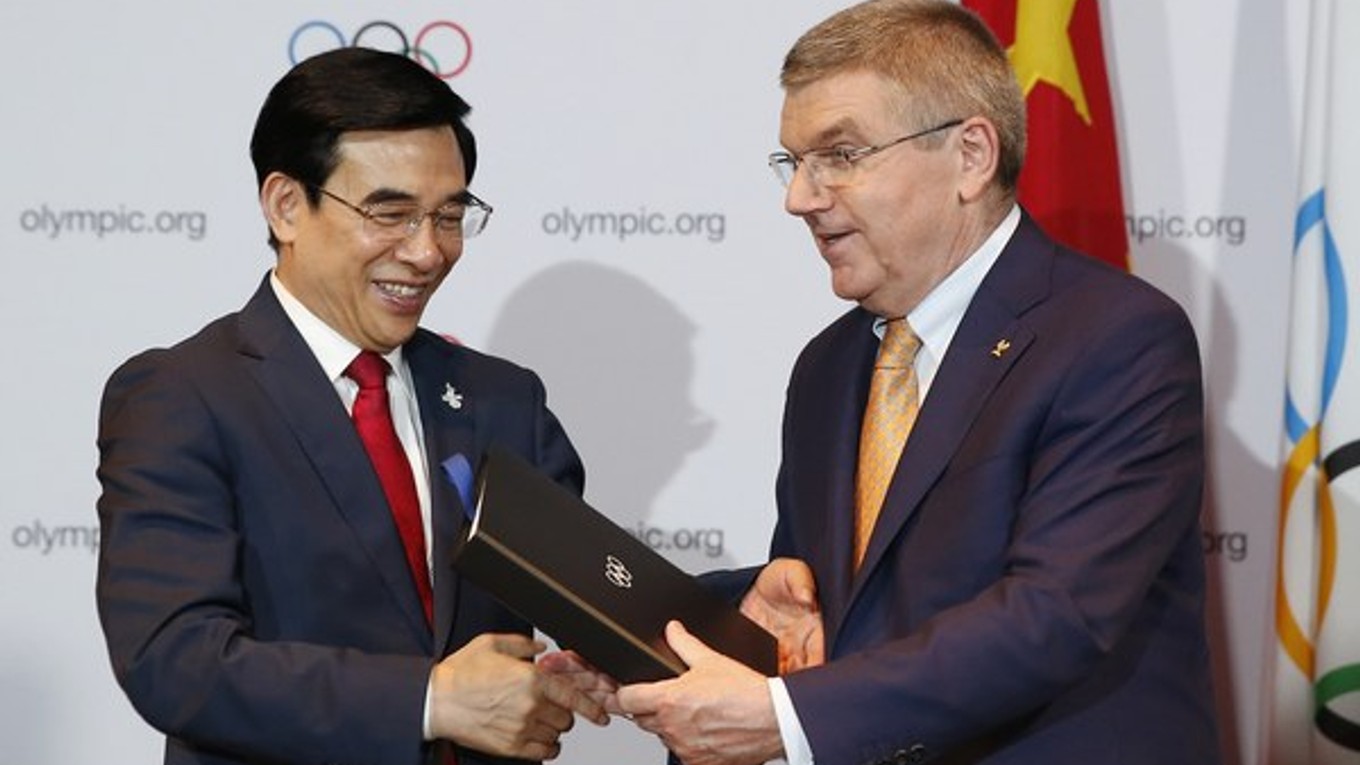 Prezident Medzinárodného olympijského výboru Thomas Bach (vpravo) blahoželá starostovi Pekingu Wang An-šunovi k získaniu práva na organizáciu ZOH v roku 2022.