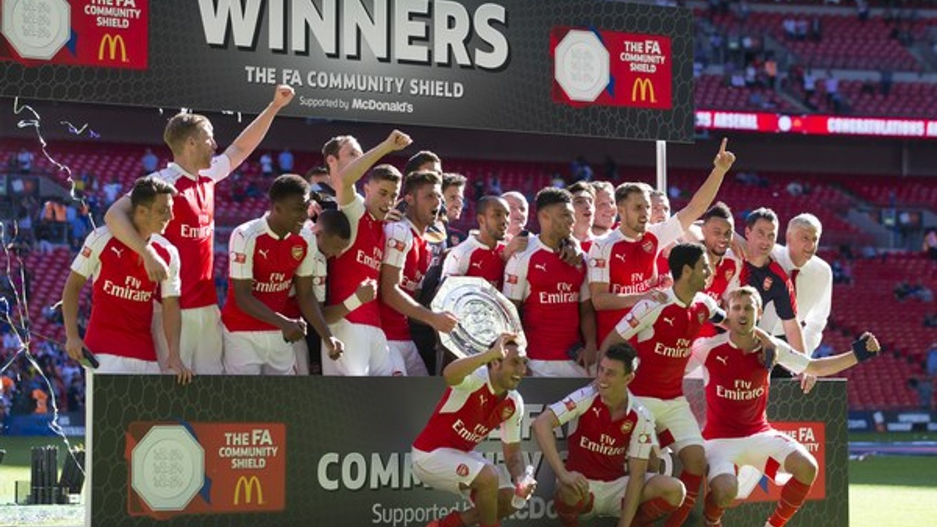 Futbalisti Arsenalu pózujú s víťaznou trofejou.