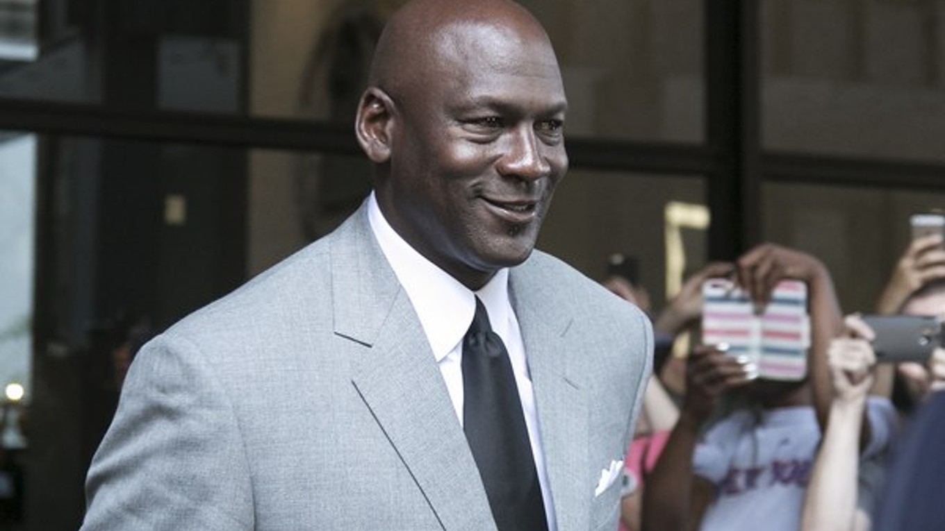 Michael Jordan opúšťa s úsmevom budovu súdu po prvom dni pojednávania.