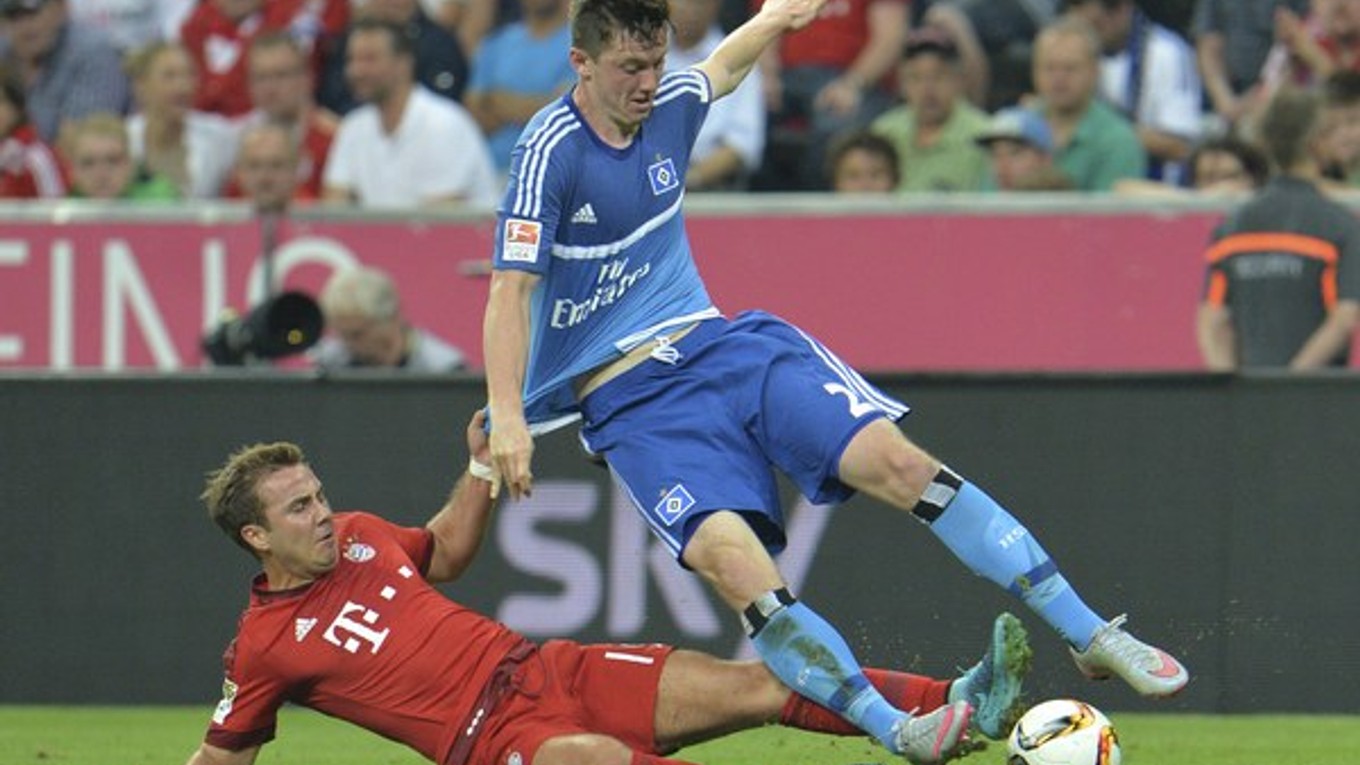 Mario Götze (vľavo) sa v súboji prvého kola nového ročníka I. bundesligy pokúša sklzom obrať o loptu hráča Hamburgu Michaela Gregoritscha.