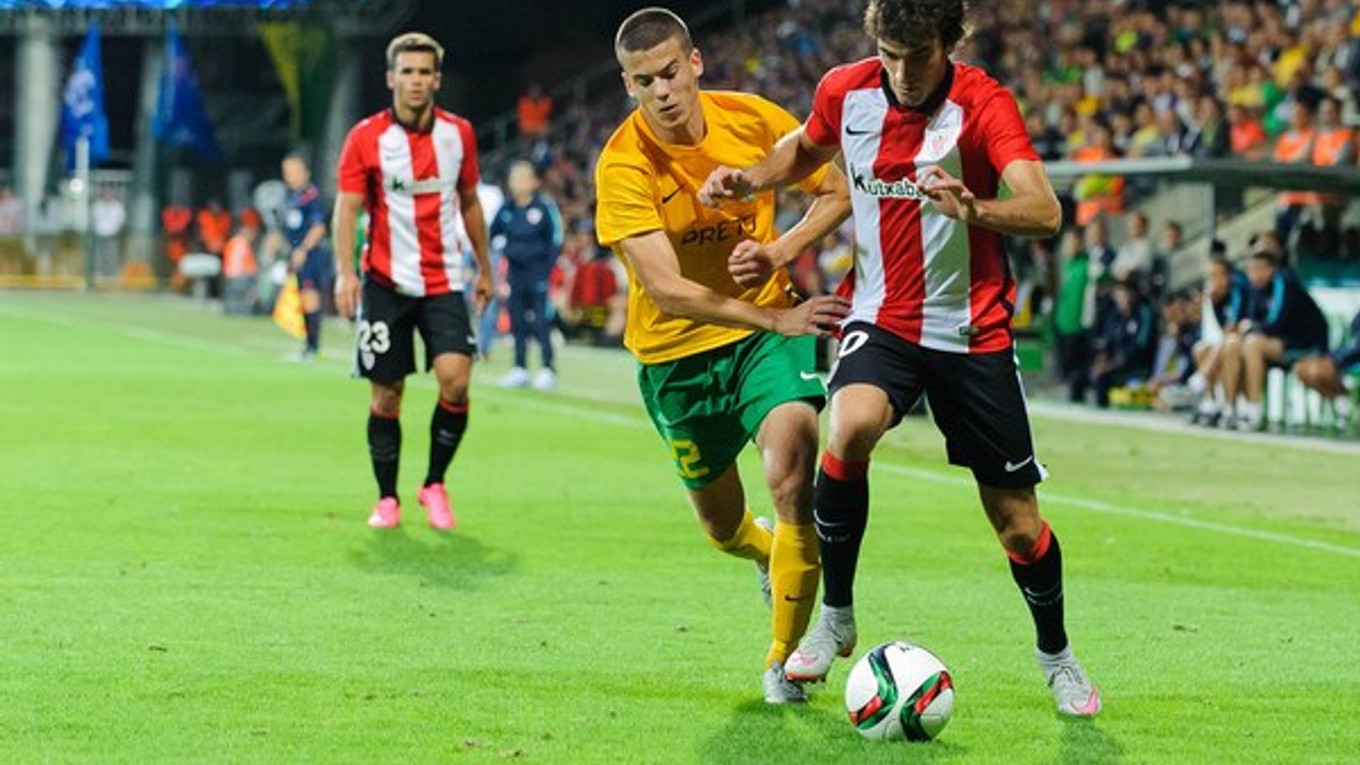 Hráč Žiliny László Bénes (v žltom) sa snaží odstaviť od lopty futbalistu Athletica Bilbao Iňiga Lekueho.