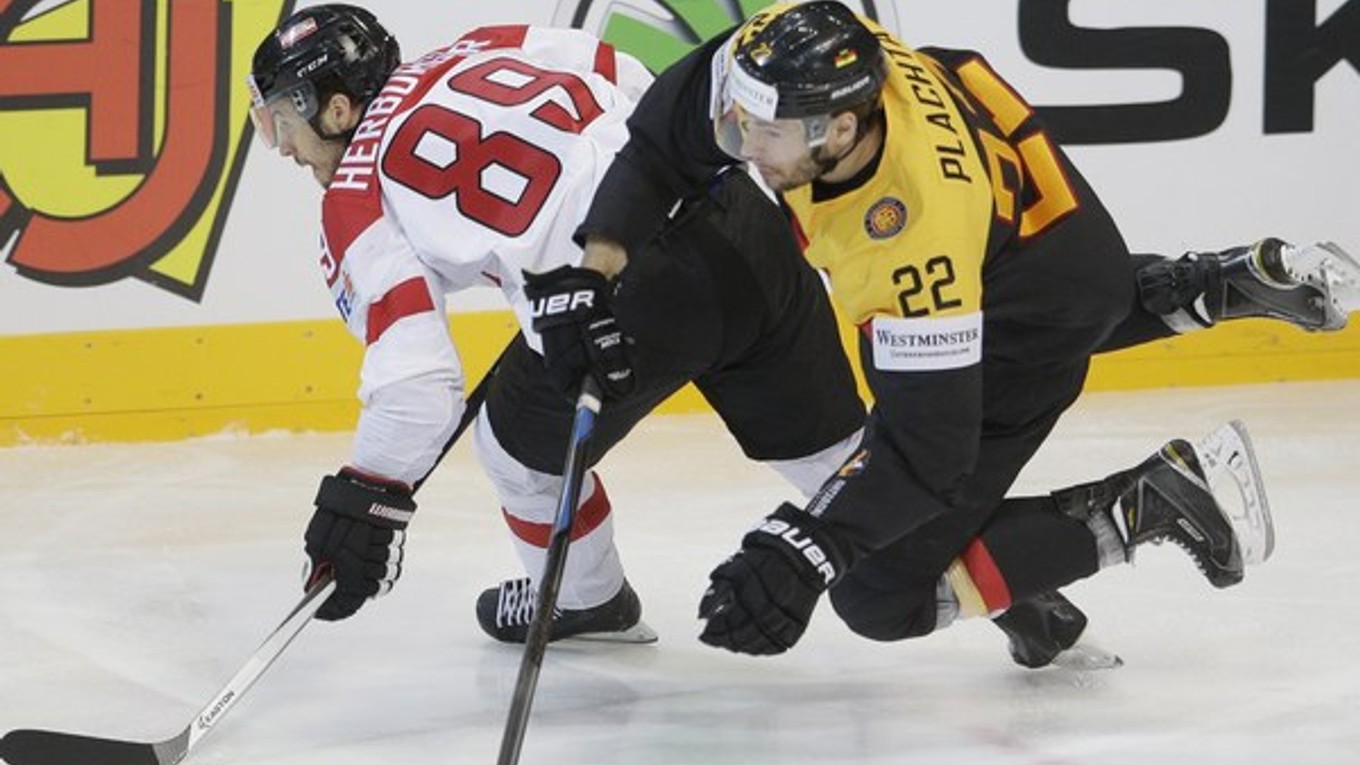 Nemec Matthias Plachta si obliekal dres Nemecka na nedávno skončených MS. Na snímke sa snaží odstaviť od puku Rakúšana Raphaela Herburgera.