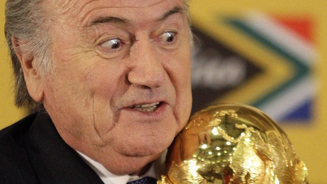 Sepp Blatter drží v rukách trofej pre majstrov sveta vo futbale.