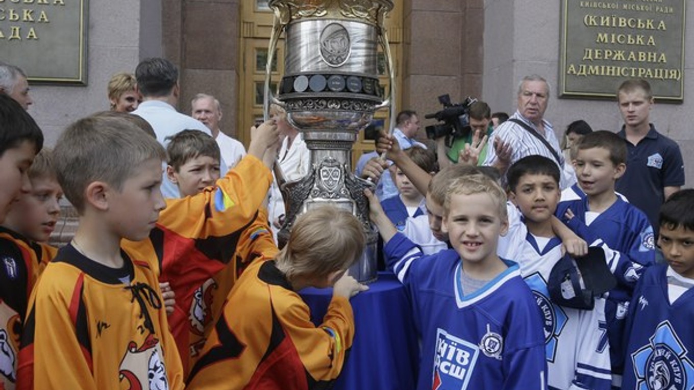 Malí hokejisti obdivujú Gagarinov pohár- trofej určenú víťazovi KHL.