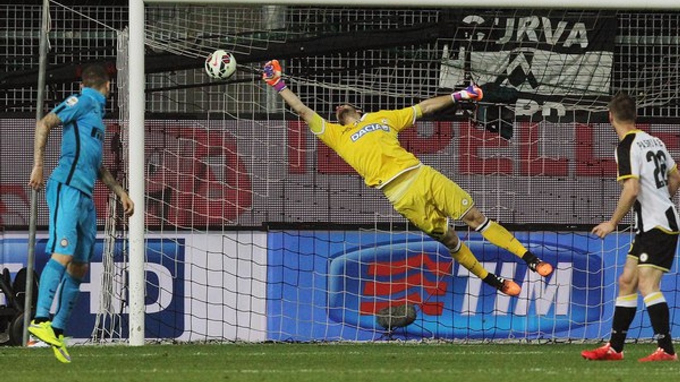 Brankár Udinese Orestis Karnezis sa márne naťahuje po lopte z kopačky Lukasa Podolského.