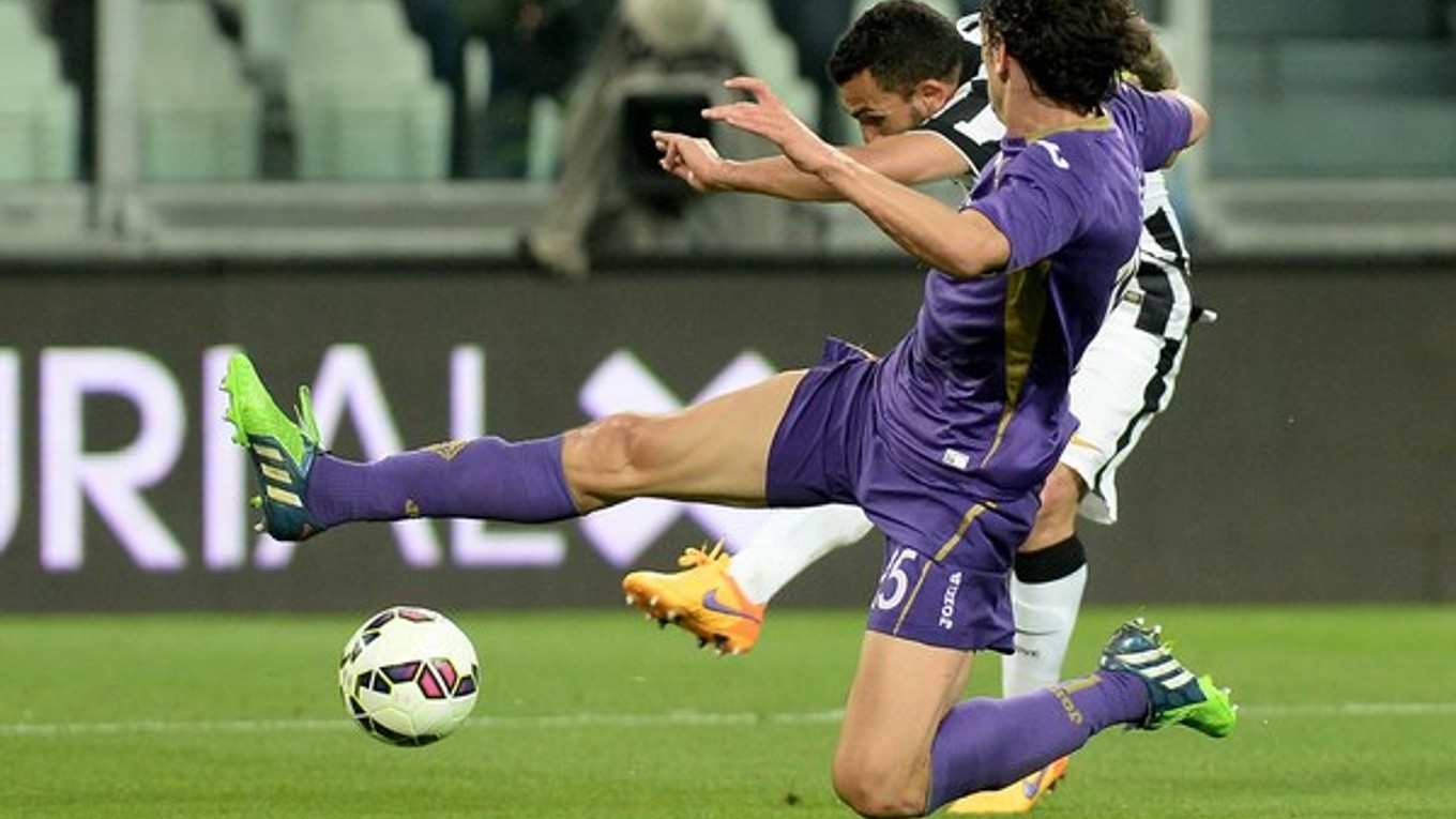 Carlos Tévez strieľa spoza brániaceho hráča Fiorentiny a dáva jeden z troch gólov Juventusu.