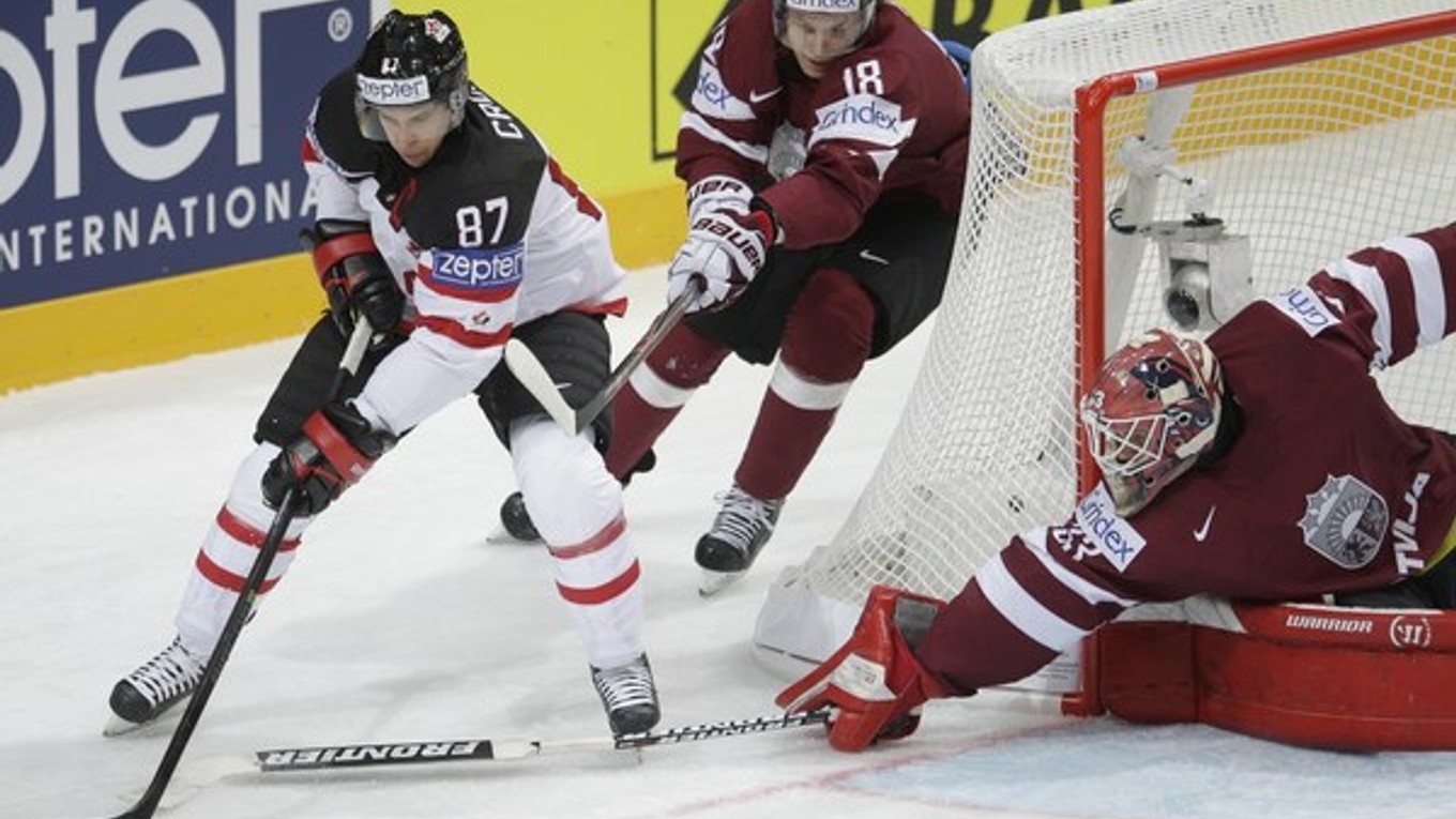 Kapitán kanadskej reprezentácie Sidney Crosby (vľavo) kontroluje puk v zápase s Lotyšskom.