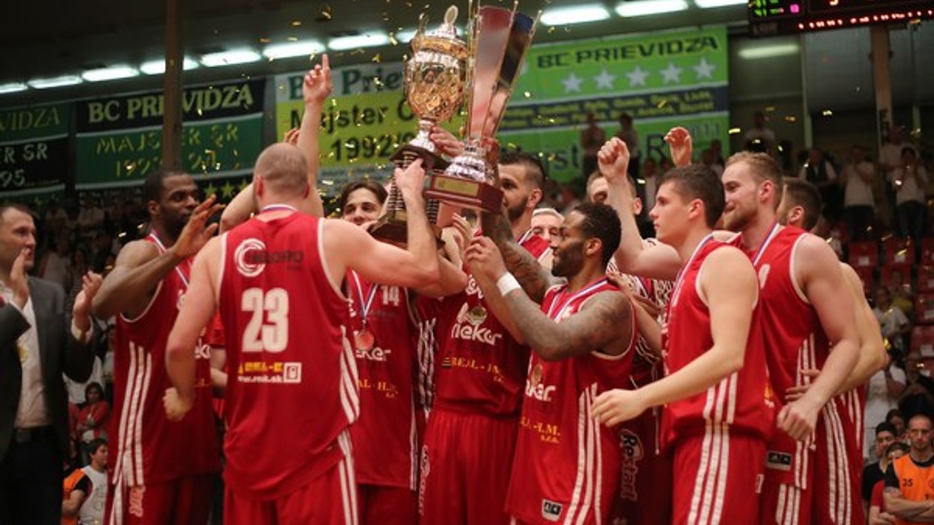 Basketbalisti Komárna dvíhajú nad hlavu majstrovský pohár.