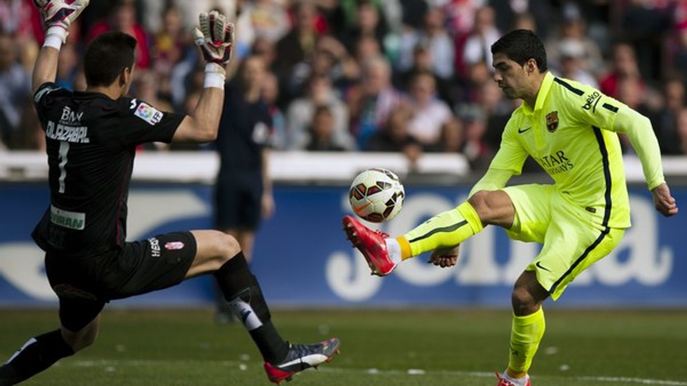 Hráč Barcelony Luis Suárez sa pokúša prehodiť brankára Granady Oiera Olazabala.