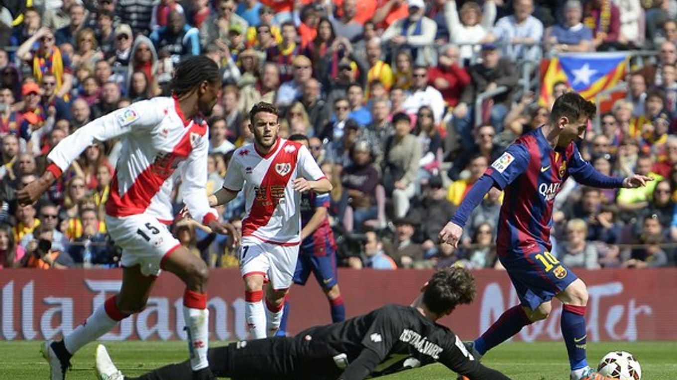 Lionel Messi (vpravo) si obchádza brankára Vallecana Cristiana Alvareza.