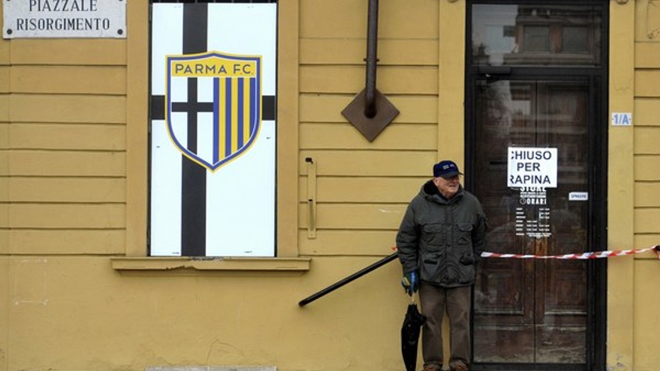 Na snímke z 8. marca stojí starší muž pred štadiónom v Parme. Nápis na dverách za jeho chrbtom hlási Chiuso per rapina (Zatvorené po lúpeži).