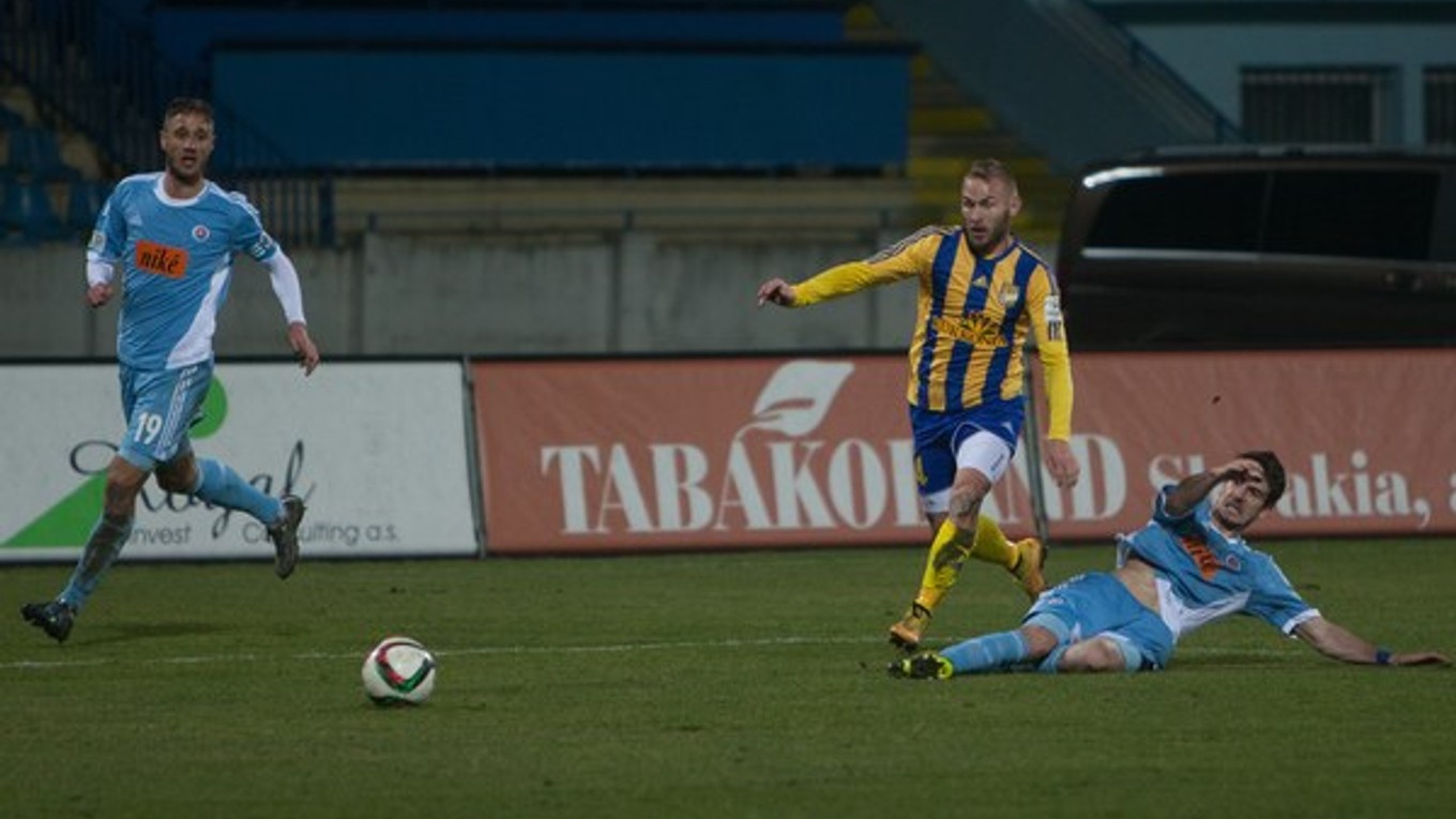Slobodan Simovič (vpravo na zemi) vypichuje loptu Petrovi Štepanovskému z Dunajskej Stredy. Slovan zápas prehral 0:1.