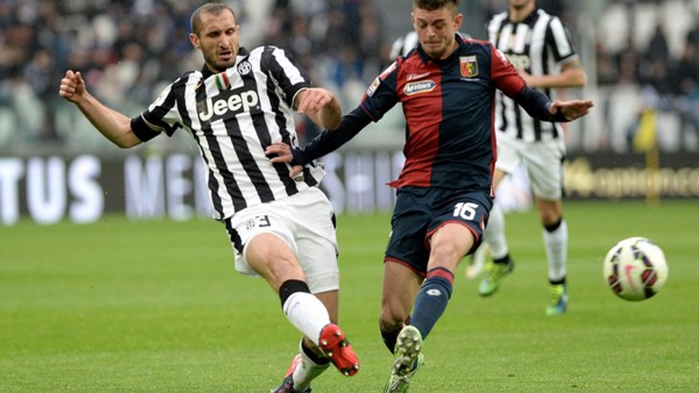 Futbalista Juventusu Giorgio Chiellini centruje loptu cez brániaceho hráča Janova Zakaryu Bergdicha.