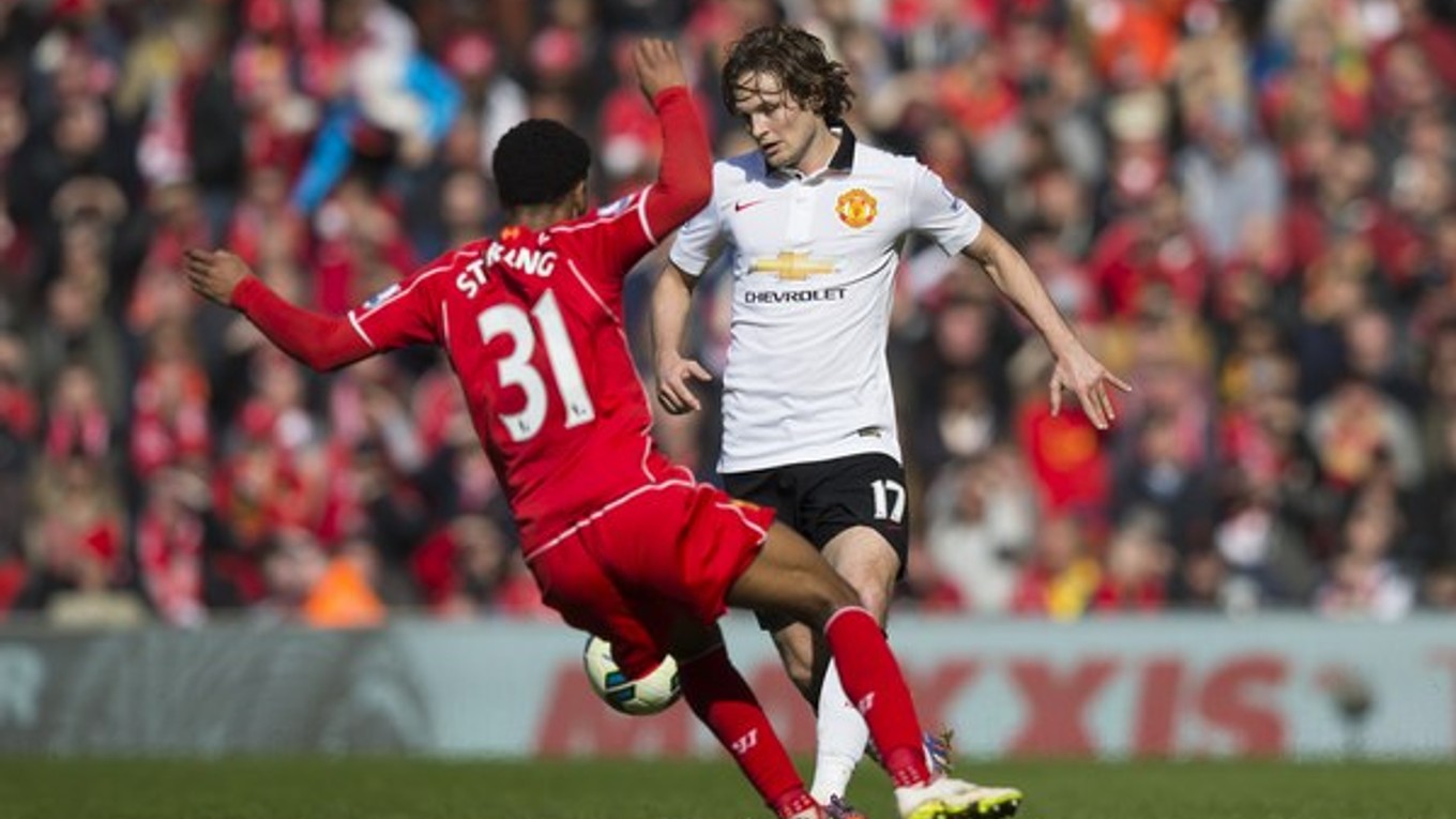 O loptu bojujú futbalista Manchestru United Daley Blind (v bielom) a hráč Liverpoolu Raheem Sterling.