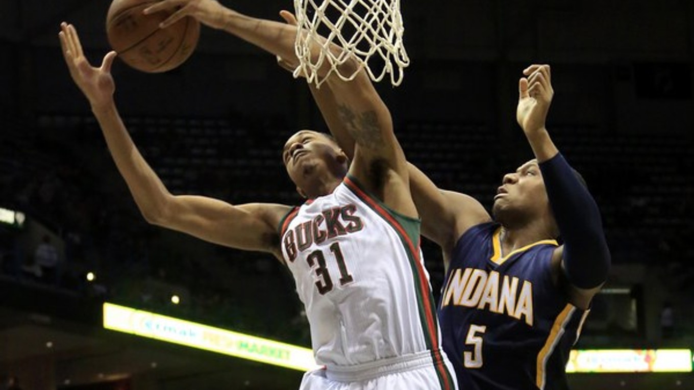 Pod košom bojujú o loptu vo vzduchu basketbalista Milwaukee John Henson (vľavo) a hráč Indiany Lavoy Allen.