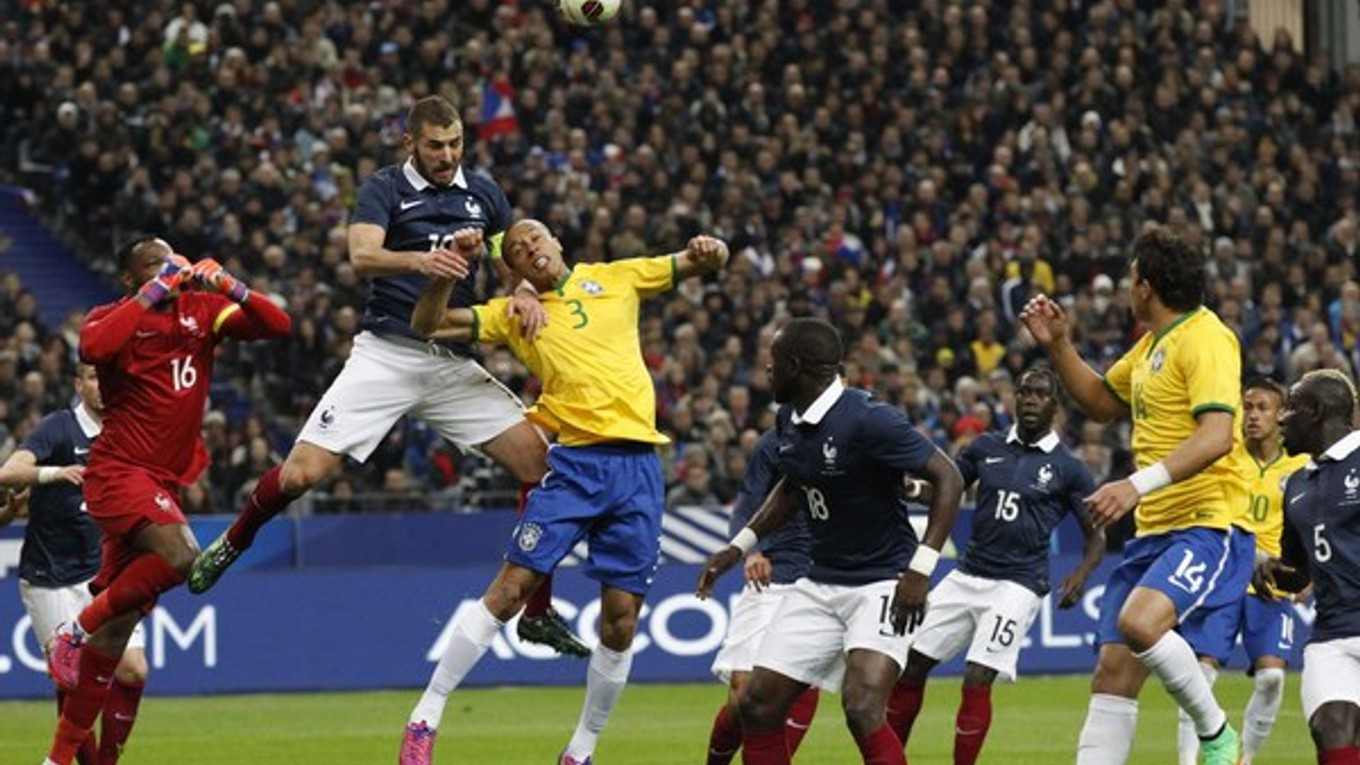 V hlavičkovom súboji bojujú o loptu Francúz Karim Benzema (najvyššie vo vzduchu) a Brazílčan Miranda.