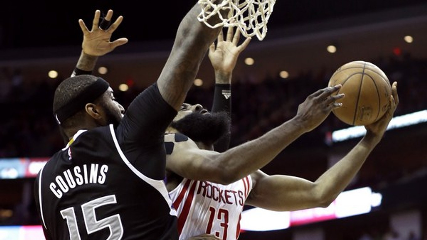 Hviezda Houstonu James Harden (vpravo) zakončuje na kôš cez brániaceho DeMarcusa Cousinsa zo Sacramenta.