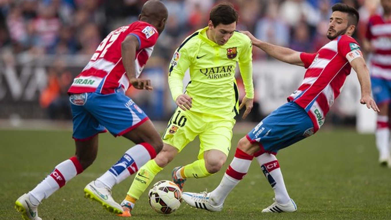 Lionel Messi (v strede) je najväčšou hviezdou FC Barcelona. Na snímke preniká cez dvoch hráčov Granady Dimitrija Foulquiera (vľavo) a Frana Rica (vpravo).