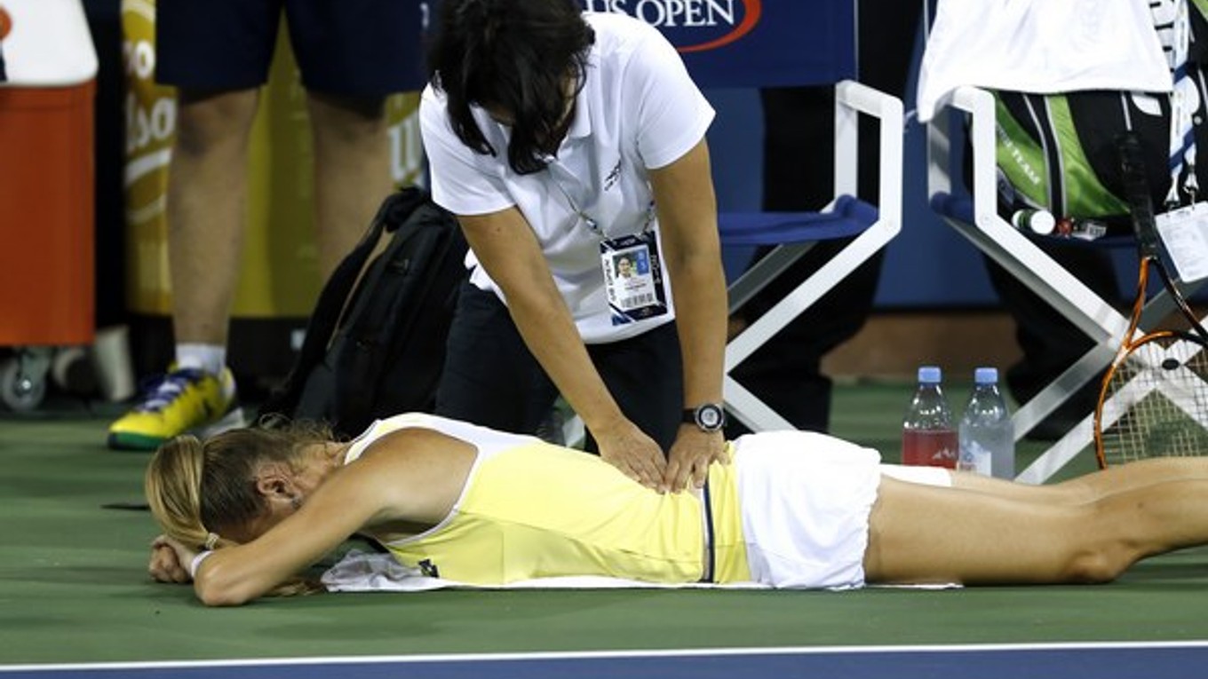 Slovenskú tenistku Magdalénu Rybárikovú ošetrujú počas zápasu 1. kola grandslamového turnaja US Open proti Dánke Caroline Wozniackej v New Yorku 25. augusta 2014.