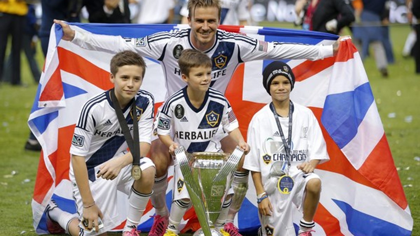 Na archívnej snímke z 1. decembra 2012 futbalista Los Angeles Galaxy David Beckham a jeho synovia Brooklyn (vľavo), Cruz (uprostred) a Romero (vpravo) pózujú s trofejou po víťazstve 3:1 v americkej MLS nad Houstonom Dynamo v Carsone.