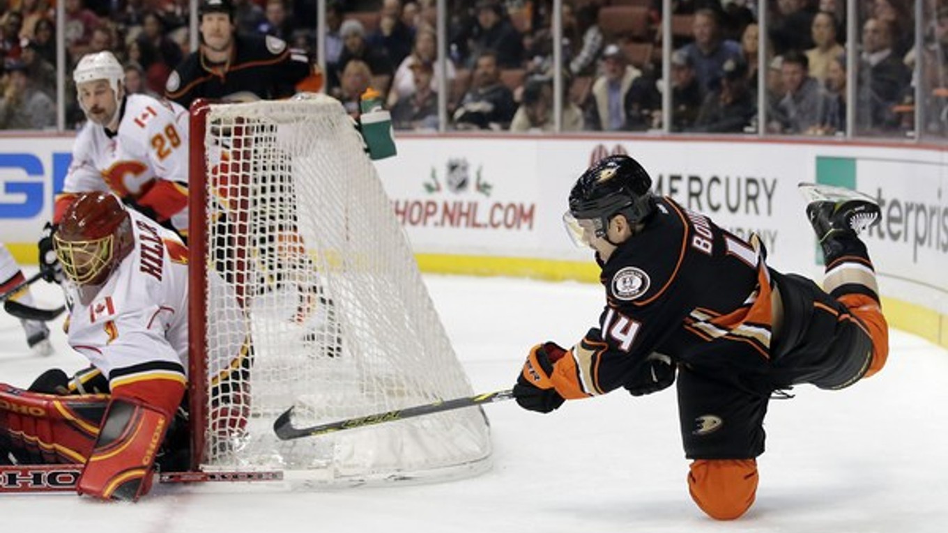 Rene Bourque z tímu Anaheim Ducks (vpravo) s brankár Calgary Flames Jonas Hiller.