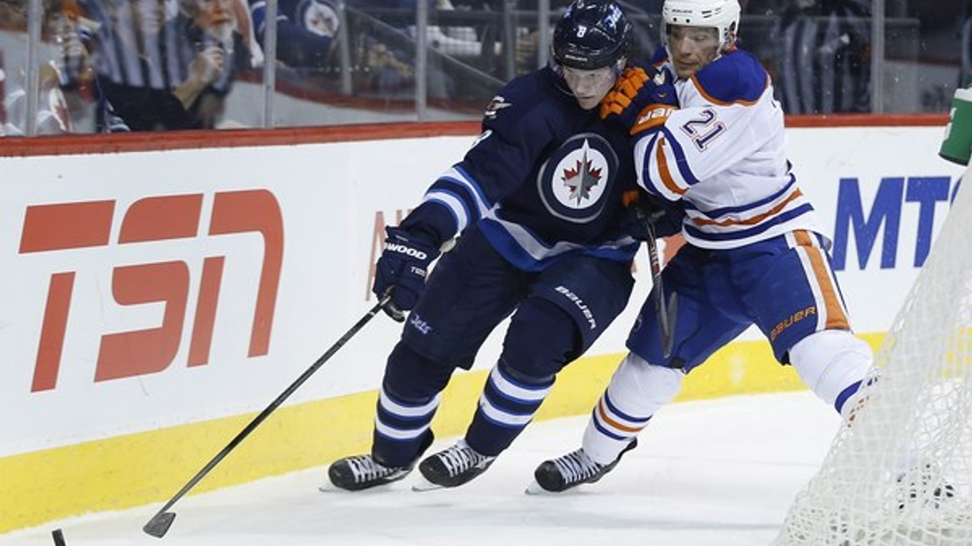 Hráč Edmontonu Oilers Andrew Ference (číslo 21) a Jacob Trouba (8) z Winnipegu.