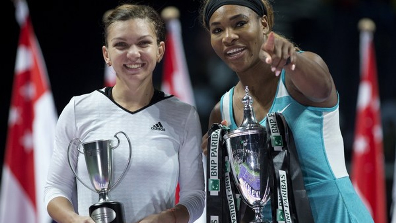 Serena Williamsová (vpravo) drží trofej po víťazstve nad Simonou Halepovou (vľavo) z Rumunska vo finále turnaja MS WTA Tour 26. októbra 2014 v Singapure.