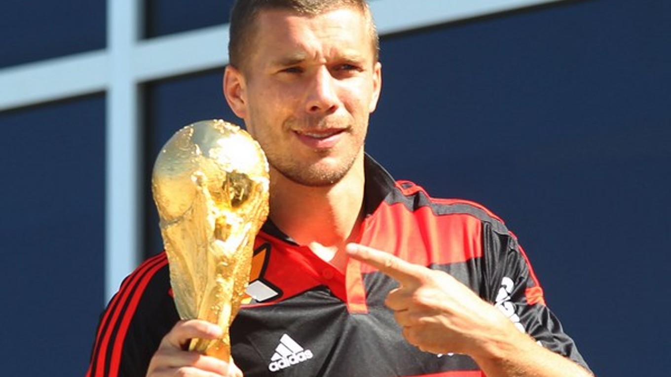 Nemecký futbalista Lukas Podolski drží trofej 14. júla 2014 v Riu de Janeiro. Nemecko zvíťazilo vo finále MS nad Argentínou 1:0 po predĺžení.