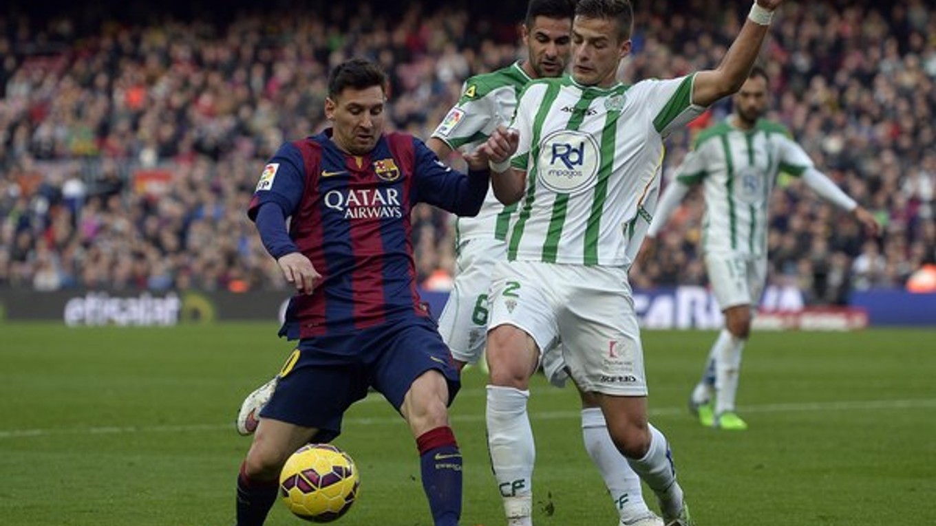 Lionel Messi v súboji s dvoma hráčmi súpera. Córdobe strelil dva góly.