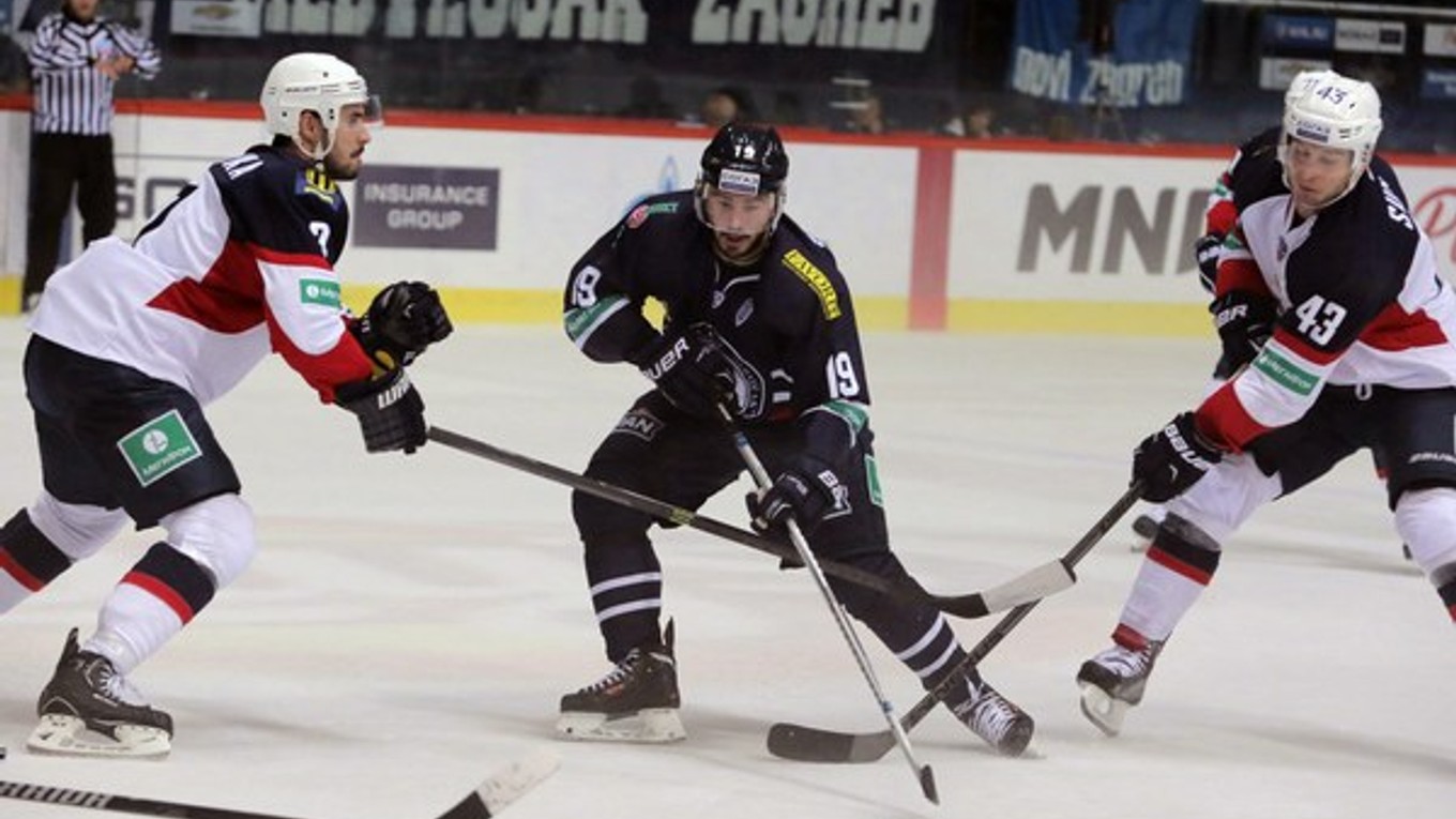 Pascal Pelletier (uprostred) z Medveščaku Záhreb a hráči Slovana Tomáš Surový (vpravo) a Ivan Baranka v zápase v Záhrebe 14. októbra 2014.