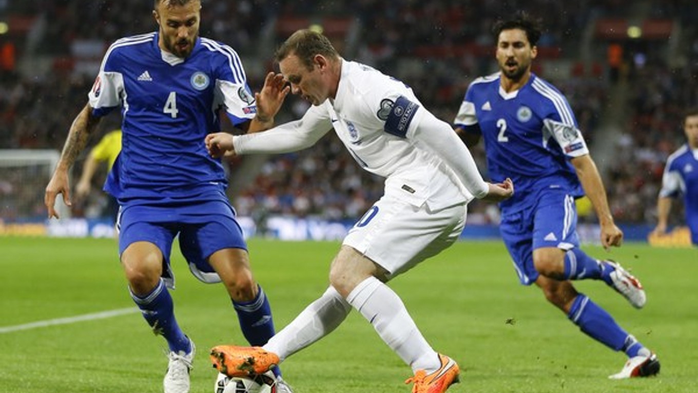 Wayne Rooney (vpredu) v súboji s Fabiom Vitaioliom zo San Marína (vľavo) vo futbalovom zápase 2. kola kvalifikácie EURO 2016 v Londýne 9. októbra.
