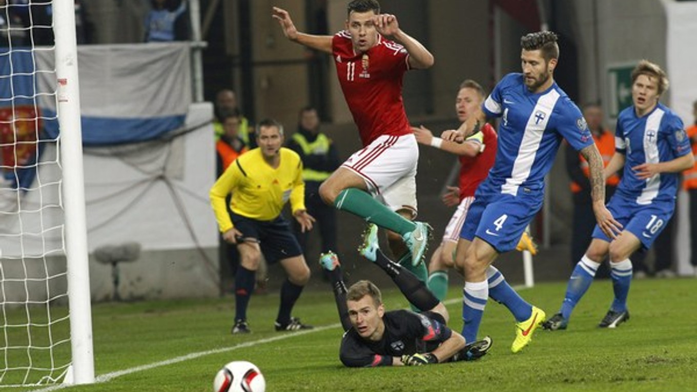 Fínsky brankár slovenského pôvodu Lukáš Hradecký (dole), hore maďarský hráč Adam Szalai, vpravo fínsky hráč Joona Toivio v zápase 4. kola kvalifikácie EURO 2016 v F-skupine Maďarsko - Fínsko v Budapešti 14. novembra 1:0.