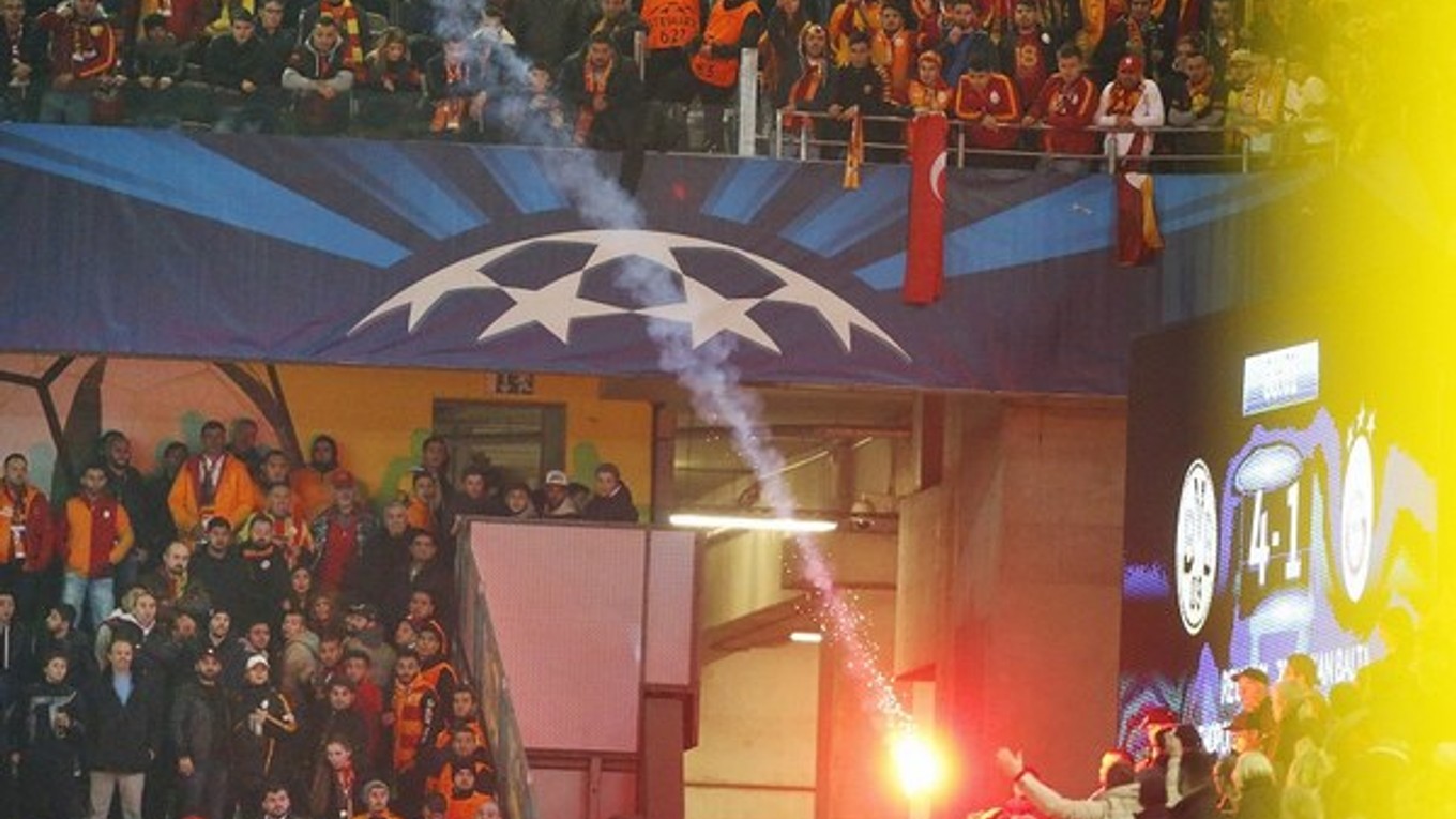 Fanúšikovia Galatasarayu hádžu svetlice počas zápasu na štadióne Borussie Dortmund.