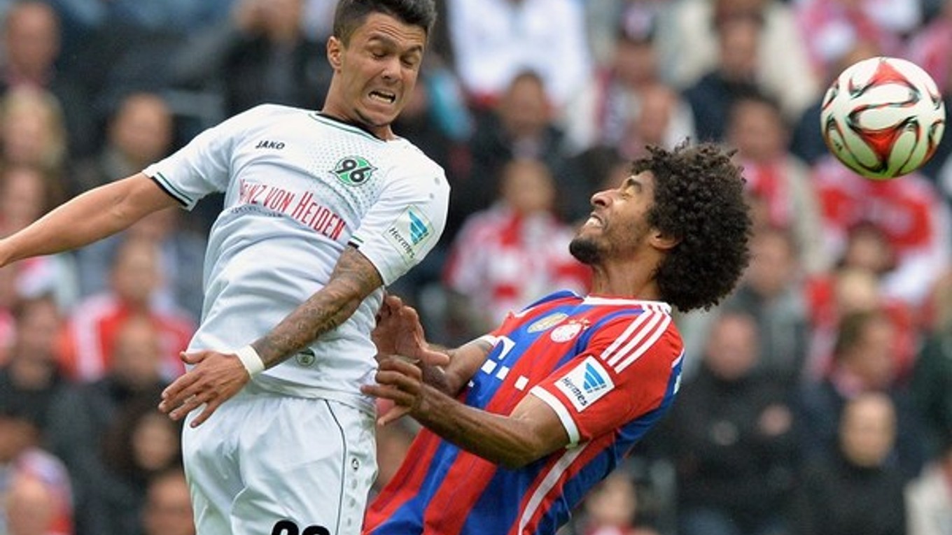 Dante (vpravo) z Bayernu Mníchov v súboji s Hannoverčanom Leonardom Bittencourtom.