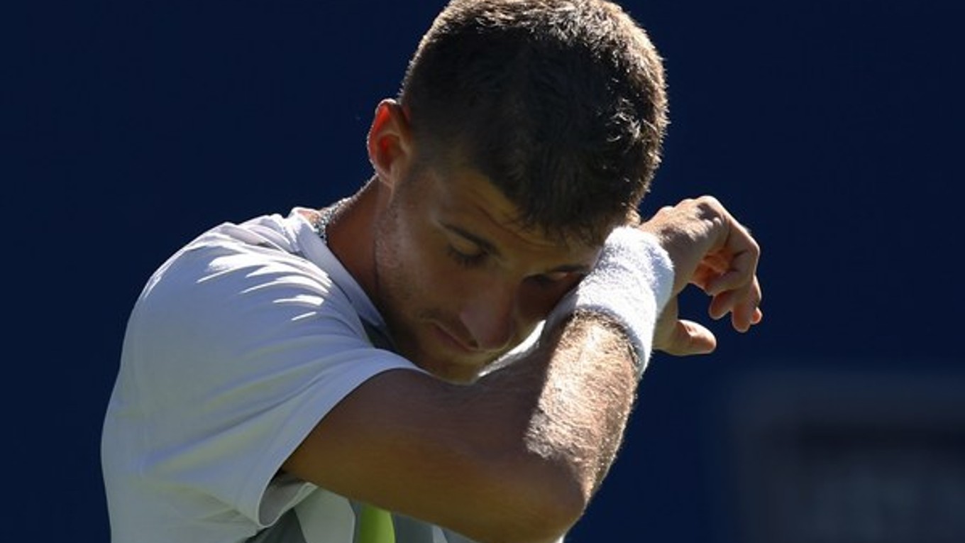 Slovenský tenista Martin Kližan si utiera pot počas zápasu proti Čechovi Tomášovi Berdychovi.
